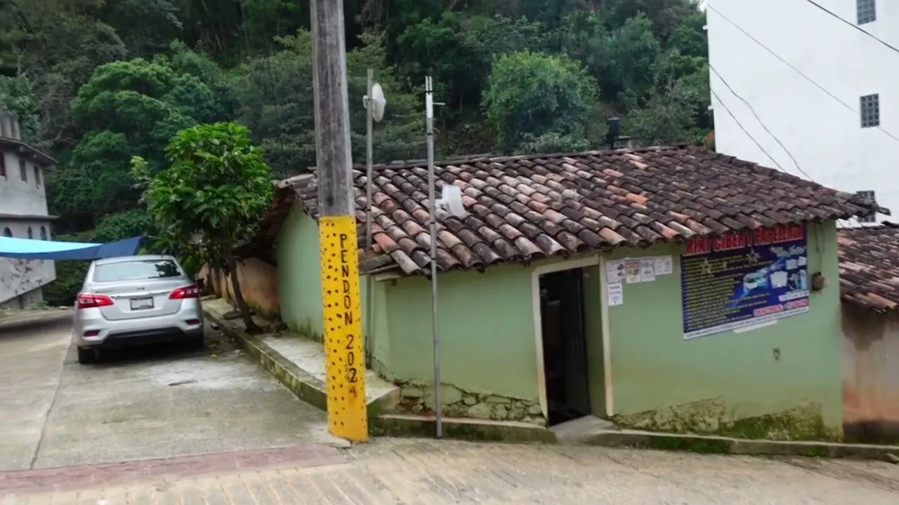 Una casa de adobe con teja y uno de los postes pintados